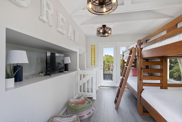 bedroom with lofted ceiling, access to exterior, an inviting chandelier, and hardwood / wood-style floors