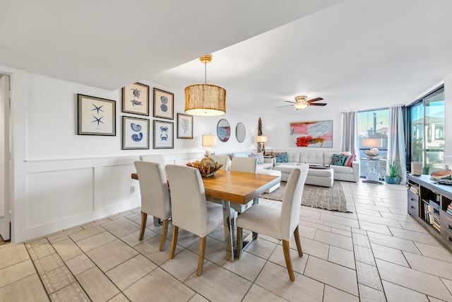 dining area with a wall of windows, light tile patterned floors, and ceiling fan