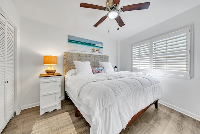 bedroom with hardwood / wood-style flooring, ceiling fan, and a closet