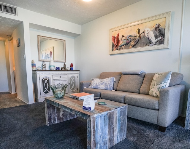 living room with a textured ceiling and dark colored carpet