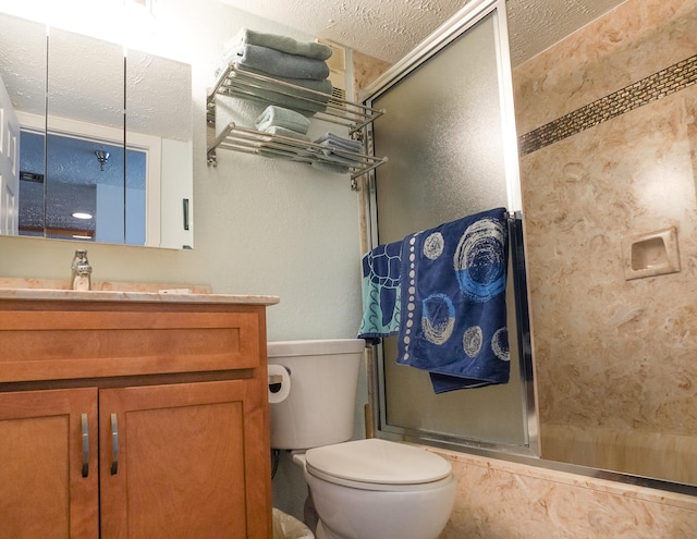 full bathroom with vanity, a textured ceiling, toilet, and shower / bath combination with glass door