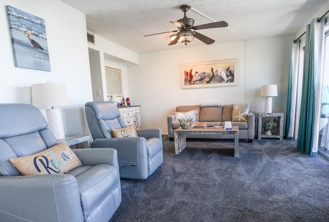 carpeted living room featuring ceiling fan and a textured ceiling