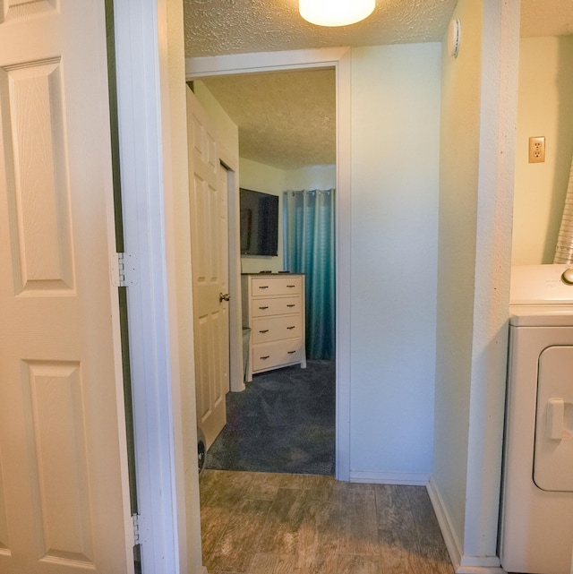 interior space featuring hardwood / wood-style flooring, a textured ceiling, and washer / clothes dryer