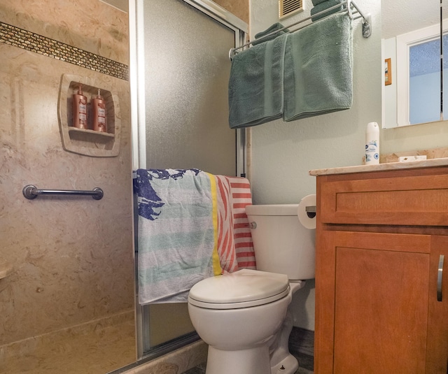 bathroom featuring toilet, vanity, and walk in shower