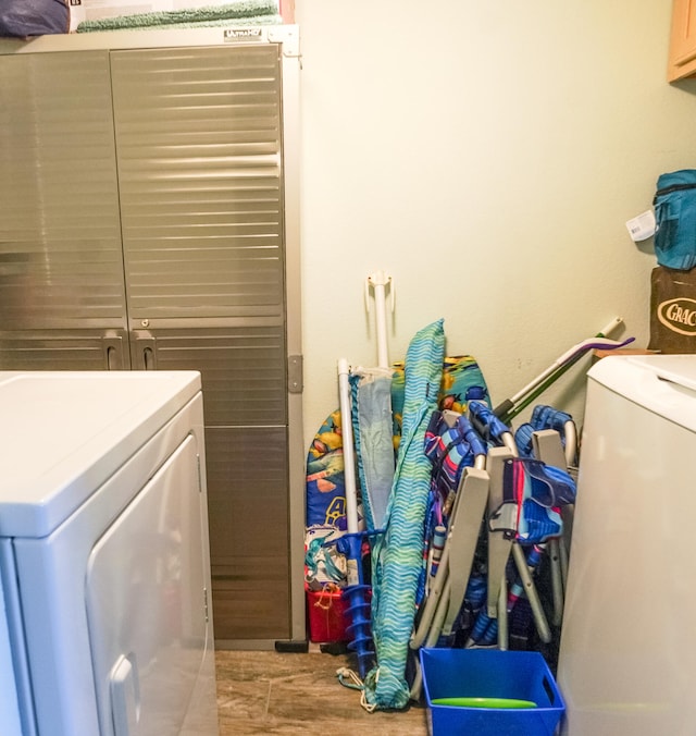 clothes washing area featuring washing machine and dryer and wood-type flooring