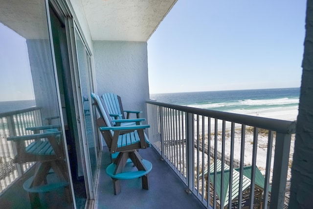 balcony featuring a water view and a view of the beach