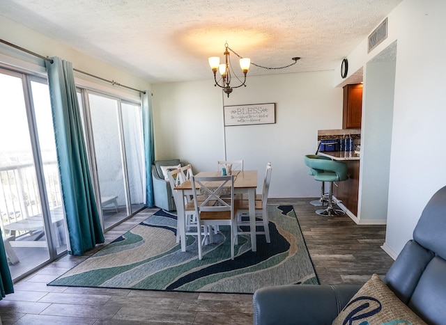 dining space featuring an inviting chandelier, hardwood / wood-style flooring, and a textured ceiling