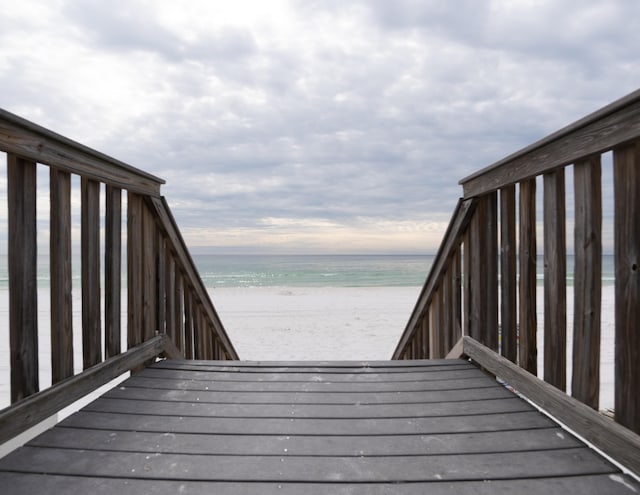 deck featuring a beach view and a water view