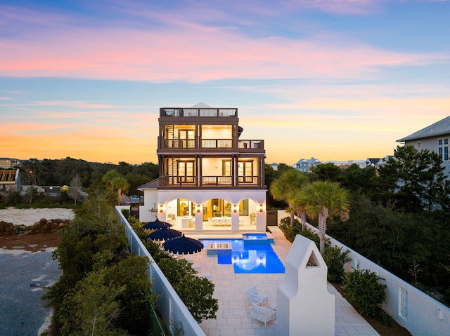 48 Paradise By The Sea Blvd, Inlet Beach, FL 32461 - back of house at dusk featuring a balcony, a fenced backyard, a patio area, and a pool with connected hot tub