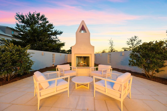 patio terrace at dusk with an outdoor fireplace