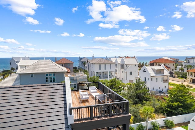 rear view of house featuring a water view and a balcony