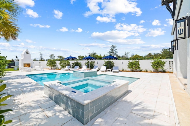 view of pool featuring exterior fireplace, a patio, and an in ground hot tub