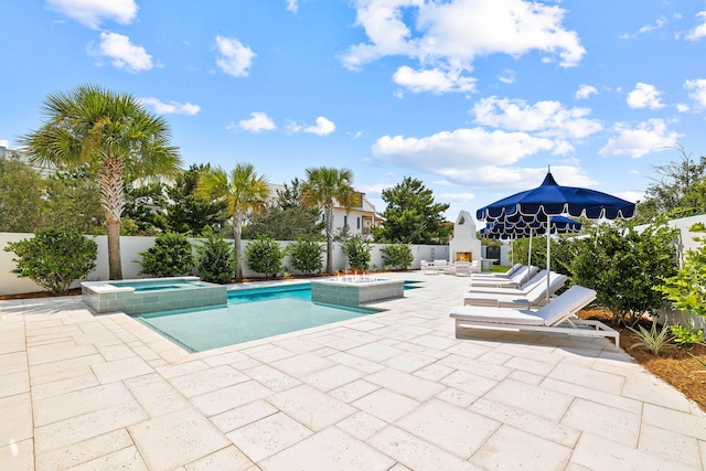 view of swimming pool featuring a patio and an in ground hot tub