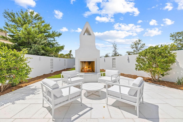 view of patio with exterior fireplace