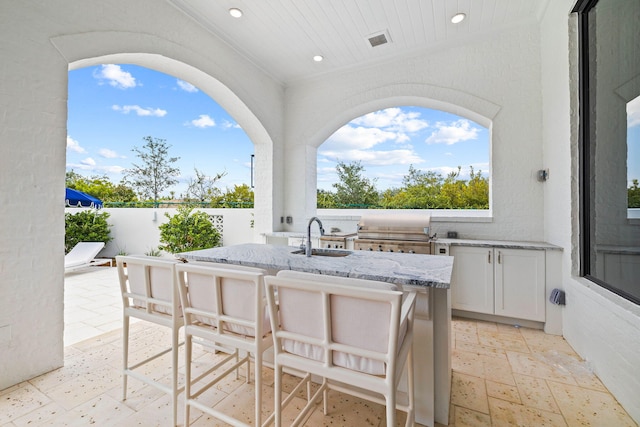 view of patio with grilling area, sink, and exterior kitchen