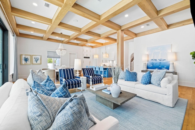 living room featuring beam ceiling, hardwood / wood-style flooring, a chandelier, and coffered ceiling