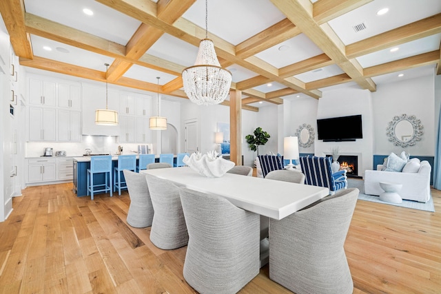 dining room featuring light hardwood / wood-style floors, beam ceiling, an inviting chandelier, and coffered ceiling