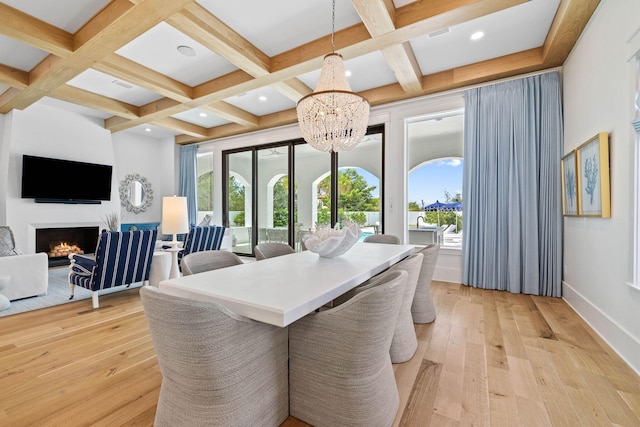 dining area with light hardwood / wood-style flooring, beam ceiling, and coffered ceiling