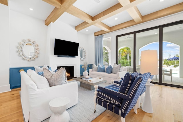 living room with a large fireplace, light hardwood / wood-style floors, and coffered ceiling