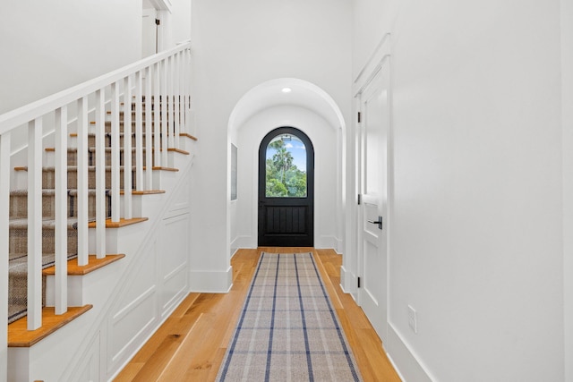 foyer with a towering ceiling and wood-type flooring