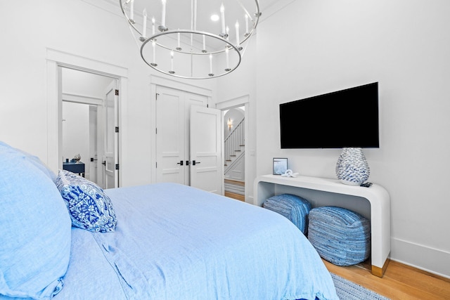 bedroom with hardwood / wood-style flooring and an inviting chandelier