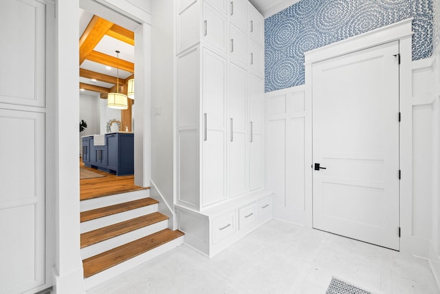 mudroom featuring beam ceiling