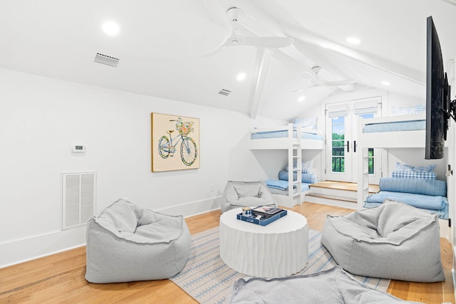 living room with ceiling fan, wood-type flooring, and vaulted ceiling with beams