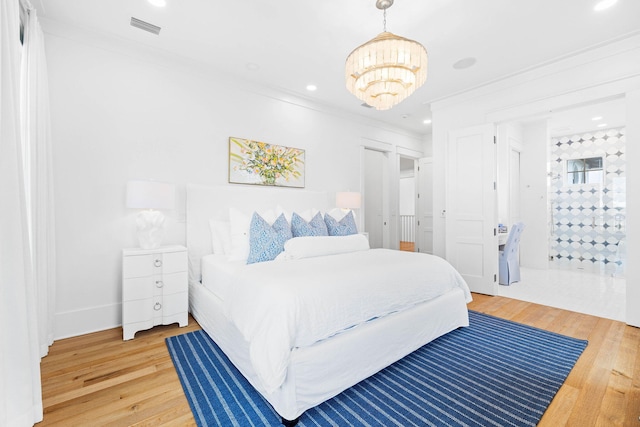 bedroom with a notable chandelier, hardwood / wood-style flooring, and crown molding