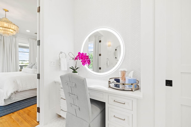 bathroom with hardwood / wood-style floors, vanity, and an inviting chandelier