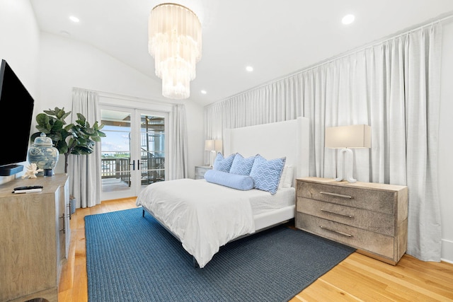 bedroom with access to outside, french doors, an inviting chandelier, vaulted ceiling, and light hardwood / wood-style floors