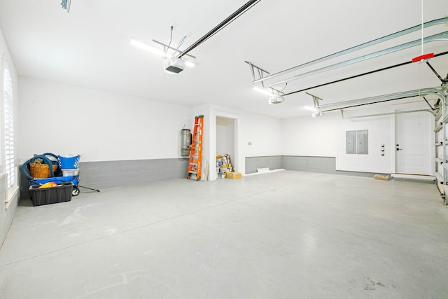 garage with a garage door opener and strapped water heater