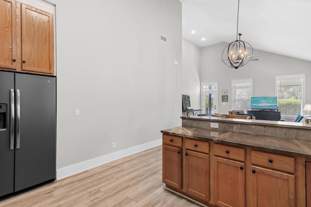 182 Pisces Dr, Santa Rosa Beach, FL 32459 - kitchen featuring stainless steel fridge, light wood finished floors, dark stone counters, a chandelier, and high vaulted ceiling