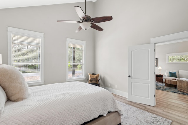 bedroom featuring high vaulted ceiling, ceiling fan, and light hardwood / wood-style flooring