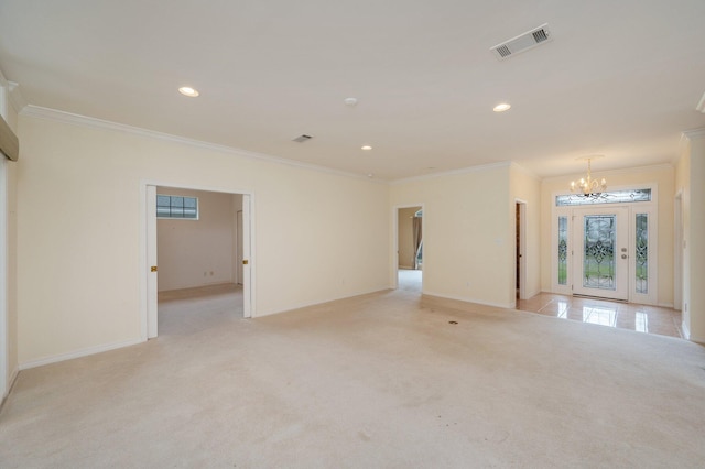 carpeted spare room with ornamental molding and a notable chandelier