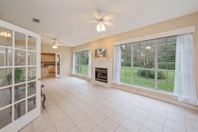 unfurnished living room featuring ceiling fan and light tile patterned floors