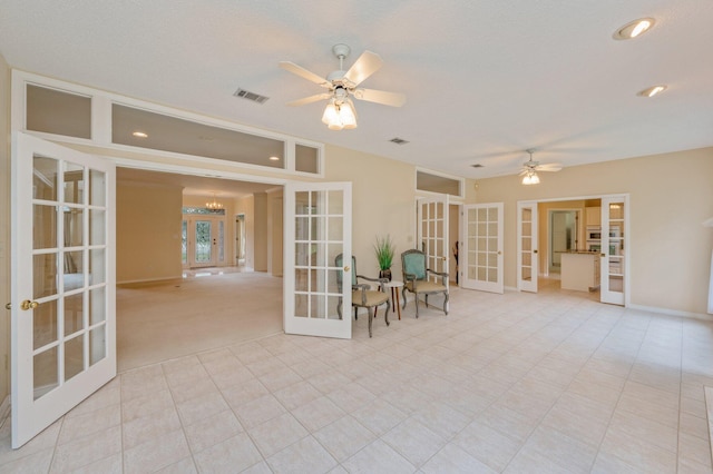 unfurnished room with ceiling fan with notable chandelier, a textured ceiling, and french doors