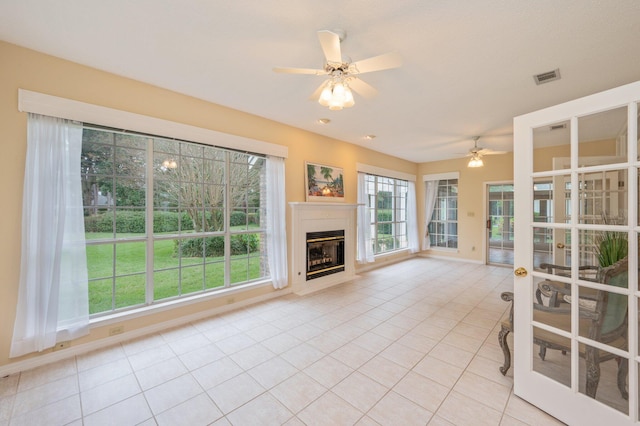 unfurnished living room featuring light tile patterned floors and ceiling fan