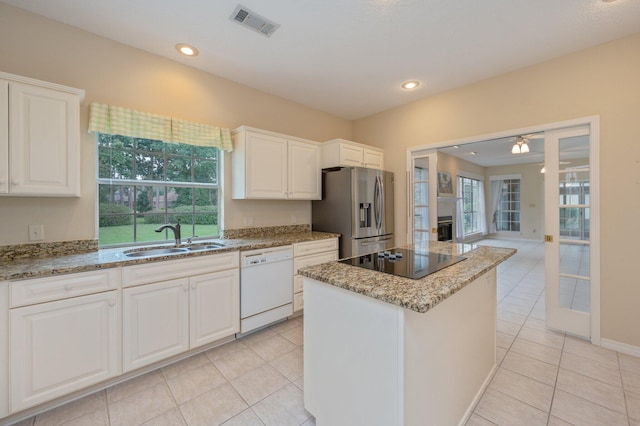 kitchen featuring black electric stovetop, white dishwasher, sink, stainless steel fridge with ice dispenser, and a center island