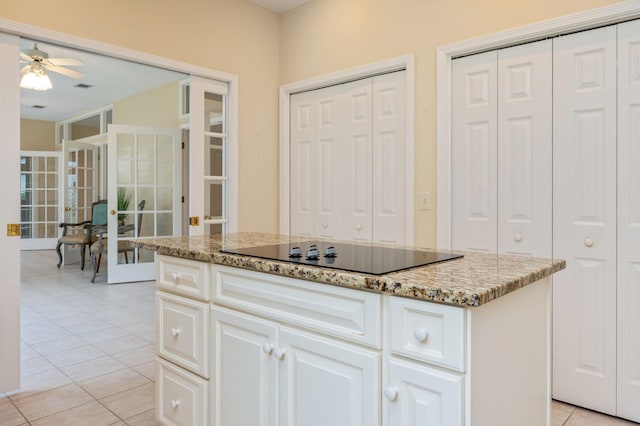 kitchen with black electric stovetop, a center island, white cabinets, and french doors