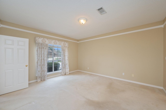 unfurnished room with light carpet, a textured ceiling, and crown molding