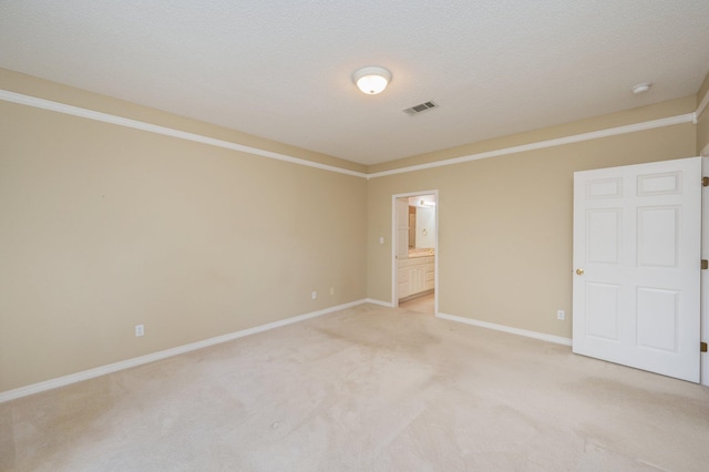 unfurnished room featuring a textured ceiling, light colored carpet, and crown molding