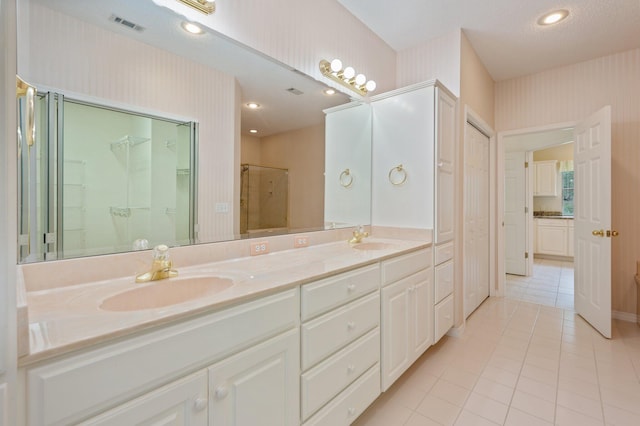 bathroom with tile patterned flooring, vanity, and a shower with door