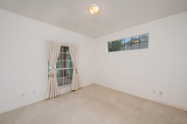 carpeted spare room featuring a textured ceiling