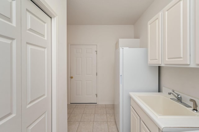 washroom featuring a textured ceiling, light tile patterned floors, and sink