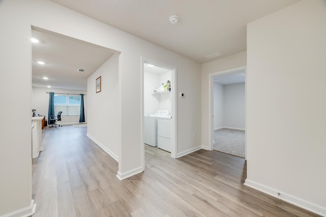 corridor featuring washer and dryer and light hardwood / wood-style flooring