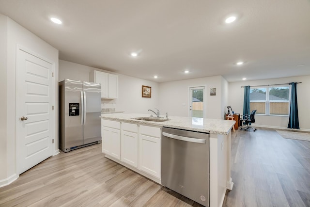 kitchen with light hardwood / wood-style floors, sink, a kitchen island with sink, white cabinetry, and appliances with stainless steel finishes