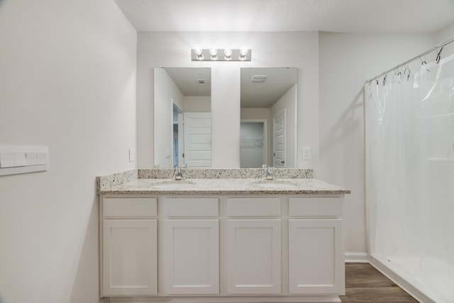 bathroom with walk in shower, wood-type flooring, a textured ceiling, and vanity