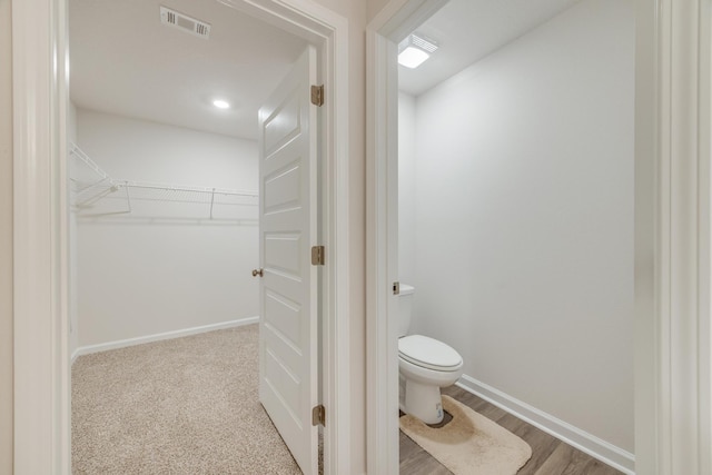 bathroom with toilet and wood-type flooring