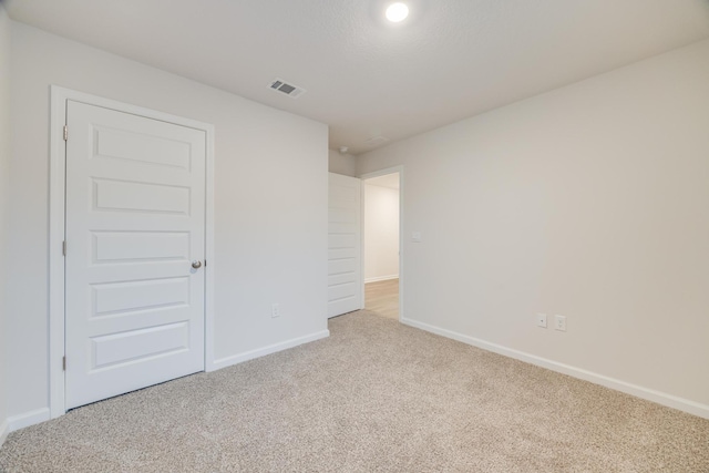 unfurnished room featuring light carpet