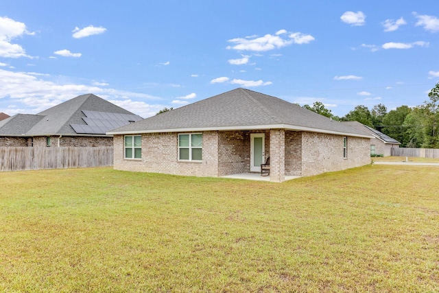 rear view of house featuring a patio area and a lawn